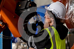 A team of male and female engineers meeting to inspect computer-controlled steel welding robots. Plan for rehearsals and