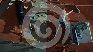 The team of a man and a woman train in the gym of the climbing wall