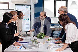 Team manager in startup business discussing with mixedrace coworkers photo