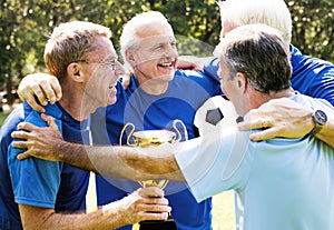 Team of mature football players winning the cup