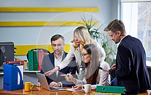 Team of mature women and men at meeting table discussing a business plan