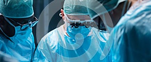 Team of medical doctors performs surgical operation in modern operating room using high-tech technology. Surgeons are