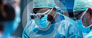 Team of medical doctors performs surgical operation in modern operating room using high-tech technology. Surgeons are