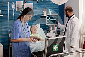 Team of medical specialists attending to elderly woman