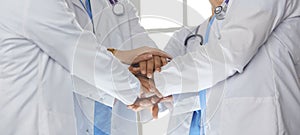 Team of medical workers holding hands together indoors, above view. Unity concept