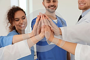 Team of medical workers holding hands together. Unity concept