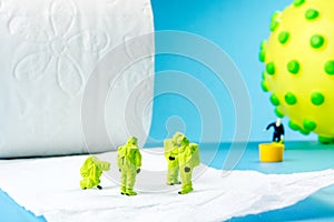 A team of miniature figurines checking a cleanliness of toilet paper as a symbol of hygiene preventive measurment