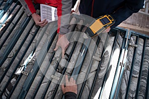 Team of mining  workers measuring drilled rock core