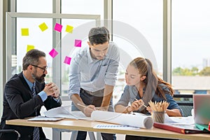 Team of multiethnic architects working on construction plans in meeting room. Engineers discussing on project in office