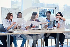 Team of multiethnic doctors having a meeting in conference room in the modern hospital. Group of multiethnic doctors are