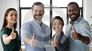 Team of multiethnic employees showing thumbs up looking at camera