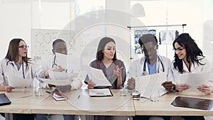 Team of multiethnic young doctors having a meeting in conference room in the modern hospital. Group of multiethnic