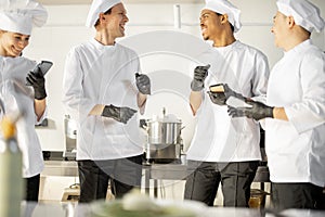 Team of multiracial cooks having conversation during a coffee break in the kitchen