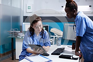 Team of nurses discussing data on tablet