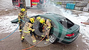 Team off Firefighters trying to cut open car door to save person involved in the accident