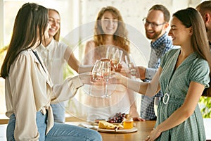 People clinking glasses with wine or champagne. Happy cheerful friends celebrate holidays, meeting. Close up shot of