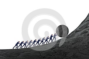 Team of people pushing stone uphill