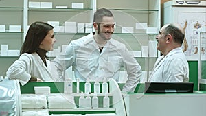 Team of pharmacist chemist woman and man standing in pharmacy drugstore and talking positive