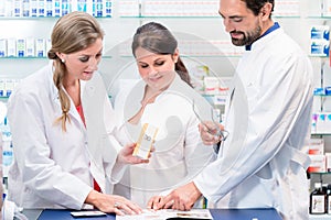 Team of pharmacists in drug store checking pharmaceuticals