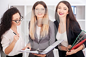 Team portrait of happy businesswomen standing on office corridor