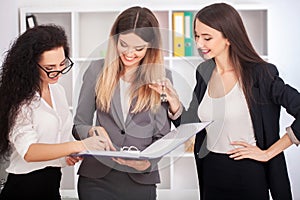 Team portrait of happy businesswomen standing on office corridor
