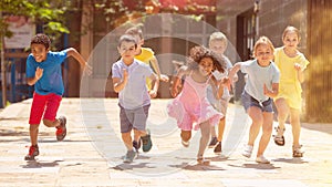 Team of positive kids running in race in the street and laughing