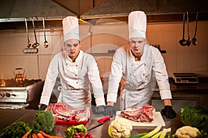 Ð team of professional chefs cook meals in the kitchen of restaurant.  Chief chef preparing dish using different food ingredients