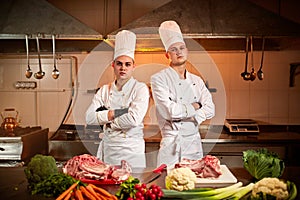 Ð team of professional chefs cook meals in the kitchen of restaurant.  Chief chef preparing dish using different food ingredients