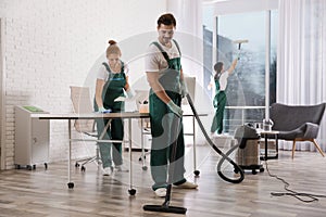 Team of professional janitors working in office. Cleaning service