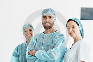 Team of professional surgeons and nurse standing in operating room before surgery