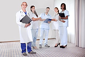 Team of professionals lead by mature doctor