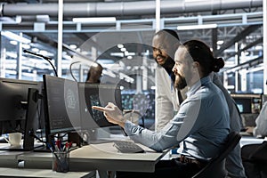 Team of programmers using computer in data center, integrating AI tools