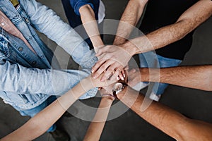 Team put hands together, show connection and alliance, Teambuilding in office, young businessmen and women in casual photo