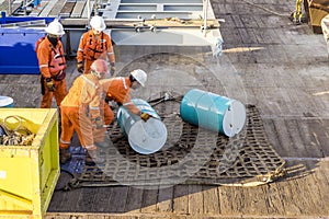 A team of riggers or roughnecks handling oil drum