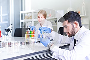 Team of scientist research working together conduct experiments in modern laboratory - Female and Male Scientists or doctor in lab