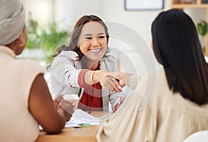 Team of smiling diverse business women shaking hands in office after meeting in boardroom. Group of happy professionals