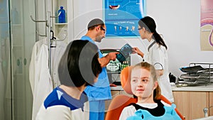 Team of stomatologist doctors analysing teeth x-ray of little patient