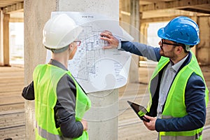 Dos exitoso joven arquitectos mira planes sobre el construcción paginas 