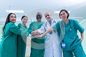 A team of surgeons in the operating room . A team of doctors standing in a hospital. Group of doctors wearing masks in front of th