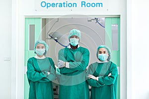 A team of surgeons in the operating room . A team of doctors standing in a hospital. Group of doctors wearing masks in front of th