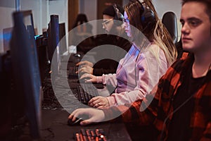 Team of teenage gamers plays in a multiplayer video game on pc in a gaming club.