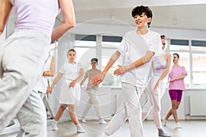 Team of teenagers rehearsing modern dances in dance hall