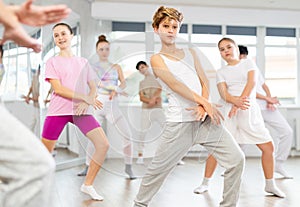 Team of teenagers rehearsing modern dances in dance hall