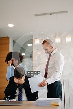 Team thinking of problem solution at office meeting, sad diverse business people group shocked by bad news, upset colleagues in