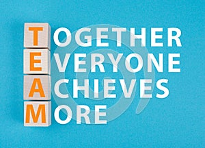 Team, together everyone achieves more is standing on a blue colored background photo