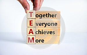 TEAM, together everyone achieves more symbol. Wooden cubes with words `TEAM, together everyone achieves more`. Beautiful white photo