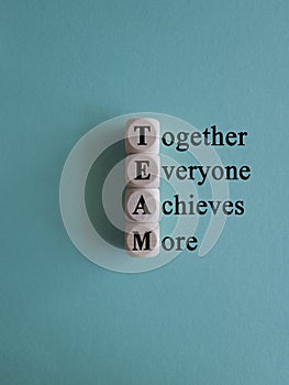 TEAM, together everyone achieves more symbol. Wooden cubes with words \'TEAM, together everyone achieves more\'