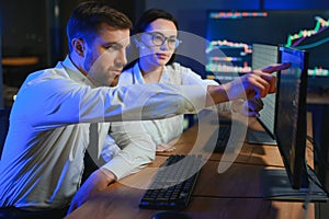 Team of traders working at monitor computer and browsing online in trading office