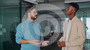 Team of two busy business men working standing in office having conversation.