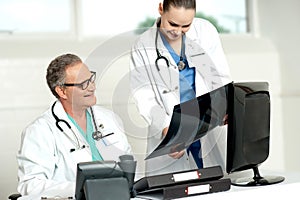 Team of two doctors reviewing x-ray report